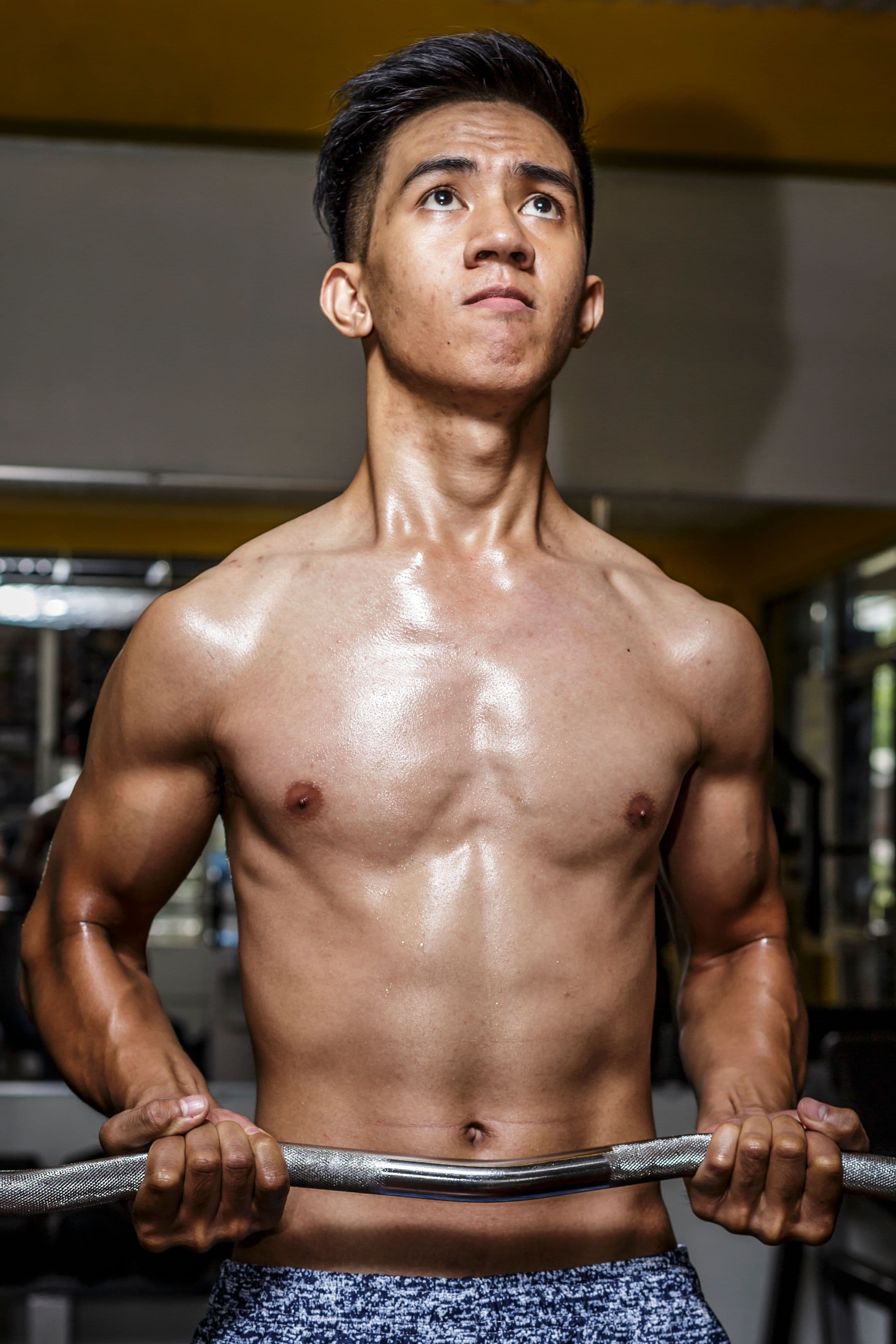 Homme portant une barre en salle de musculation